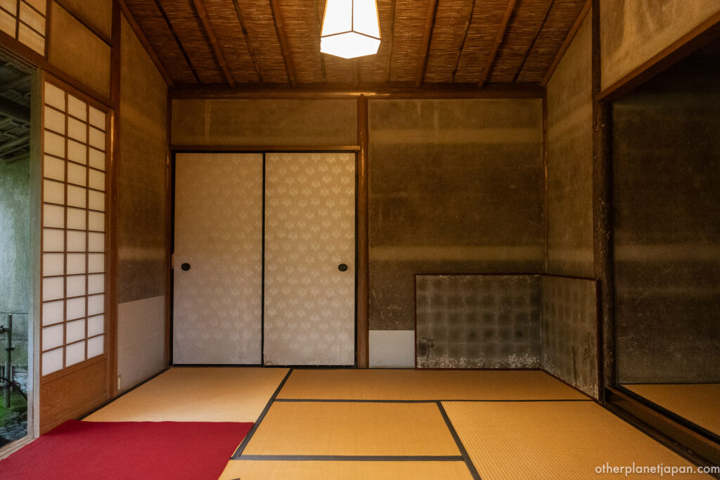 Interior of Tekisui-an teahouse with tatami mats and red felt at Okochi Sanso, Arashiyama