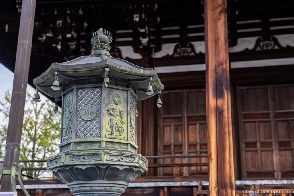Ornate bronze hexagonal lantern with cast guardian figures at Konkai-komyoji, Kyoto