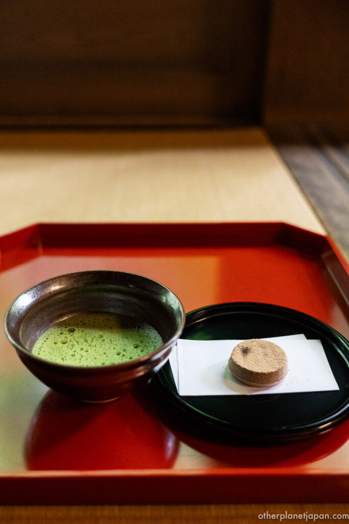 A bowl of freshly whisked matcha served with a wagashi sweet on a red lacquer tray inside the Hojo tea room at Nanzenji temple in Kyoto.