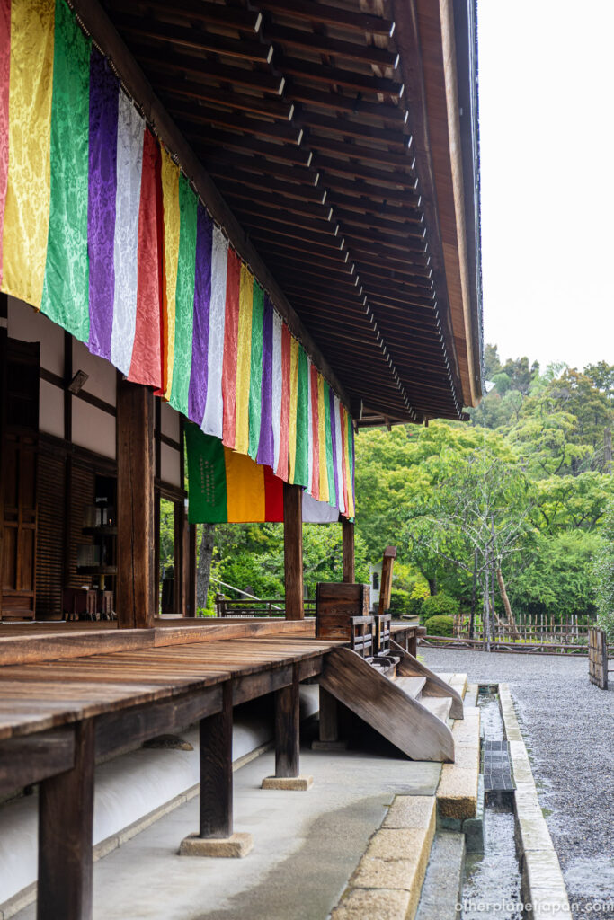 Colorful five-striped Buddhist curtain hanging from the wooden eaves of Nison-in Temple main hall