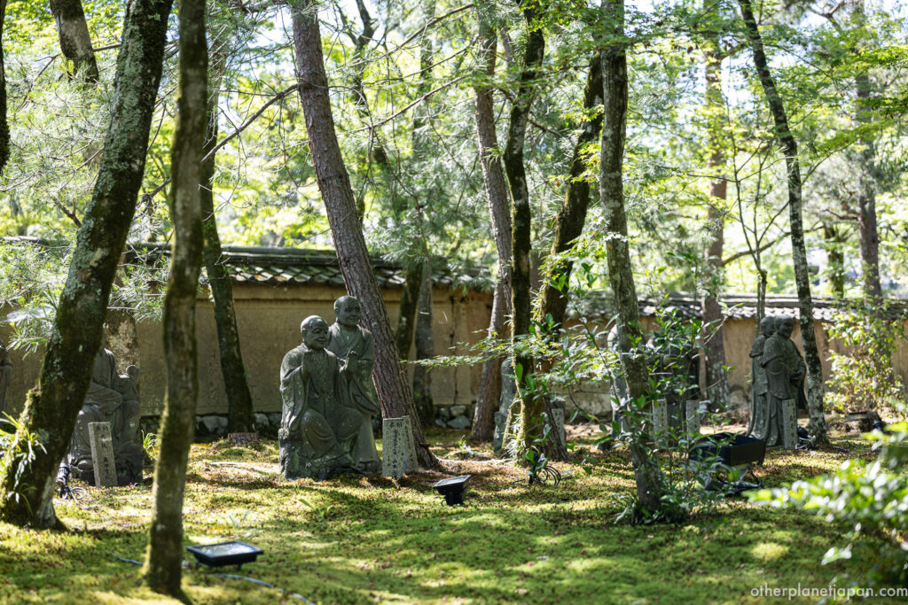 Rakan stone statues among moss at Hogonin Temple, Kyoto
