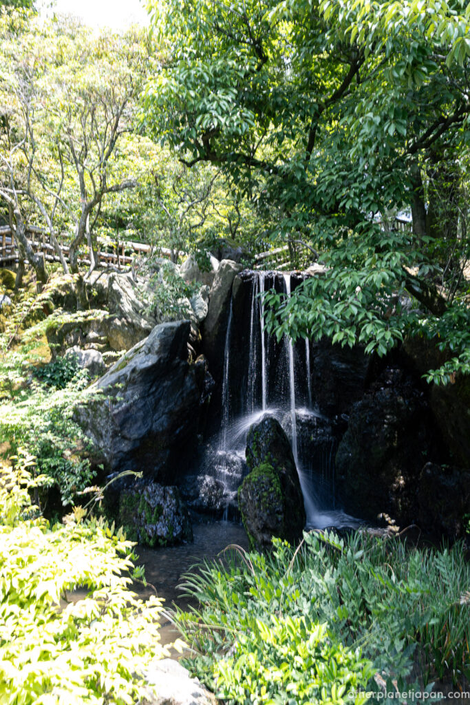 Ryumon-baku Dragon Gate Waterfall cascading over mossy rocks in the upper garden of Kinkakuji, Kyoto