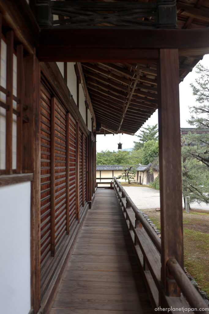 A traditional wooden engawa corridor at Daikakuji Temple looking out toward the garden and temple walls
