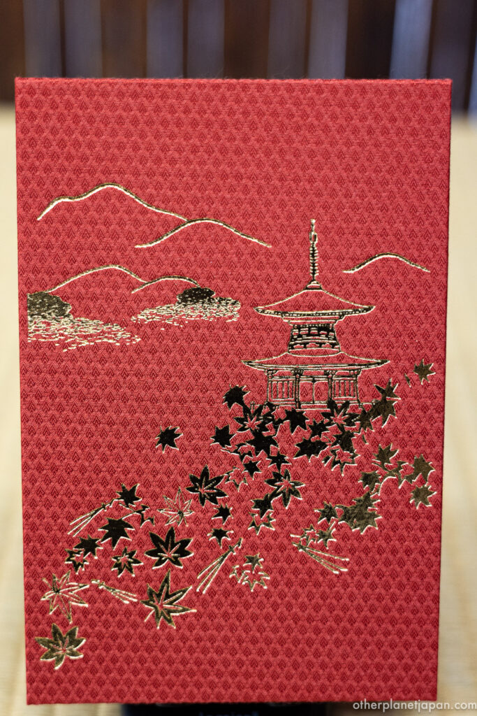 Eikando Temple's original goshuincho stamp book in crimson cloth with gold pagoda and maple leaf design