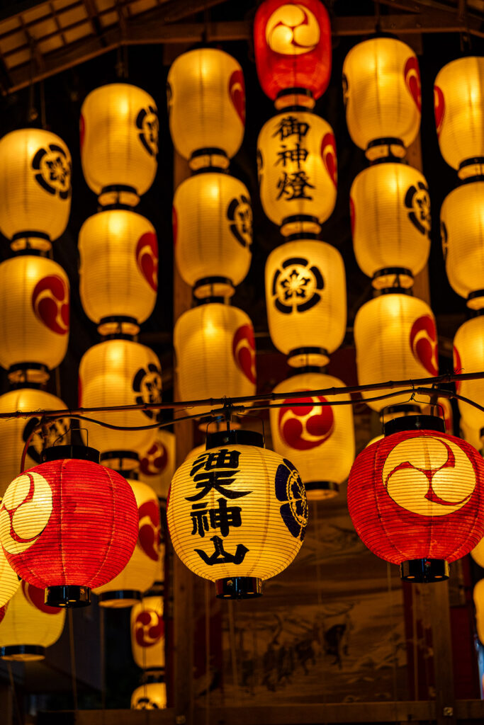 Wall of red and white illuminated chochin lanterns at a Gion Matsuri float at night