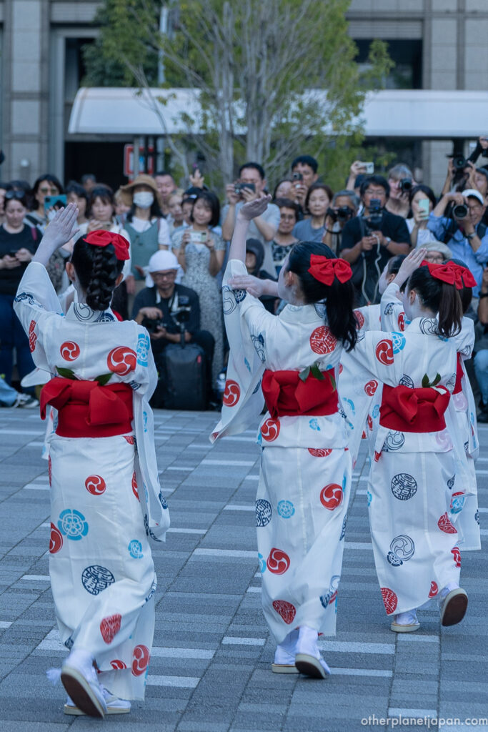 Komachi Odori dancers in lavender and pink kimono with green obi performing at Kyoto City Hall