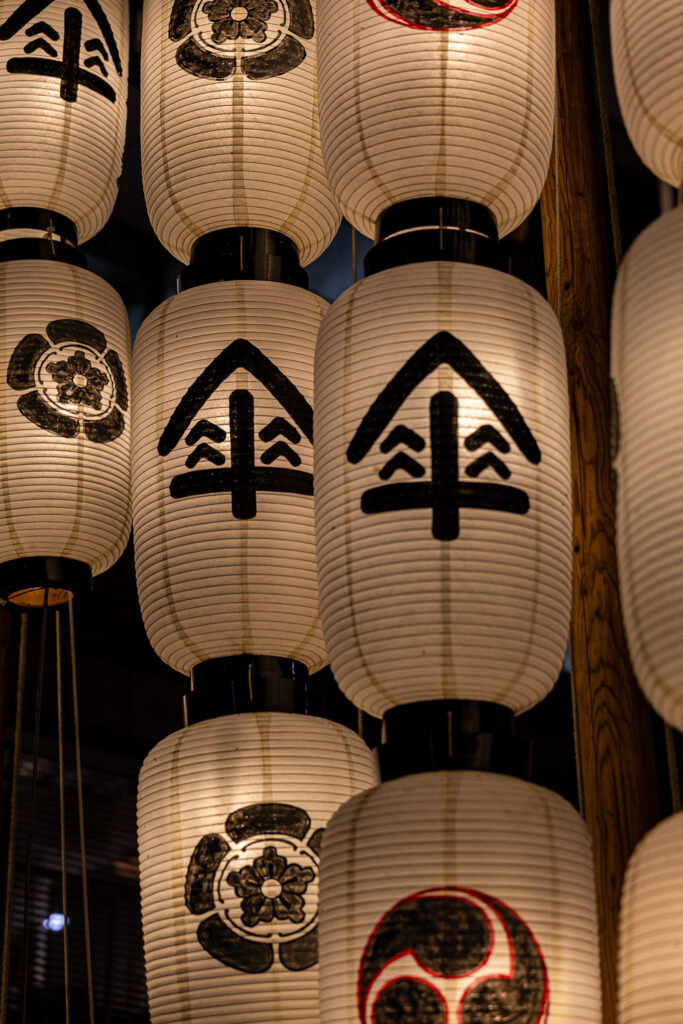Close-up of white paper lanterns with black umbrella crests at the Gion Festival in Kyoto