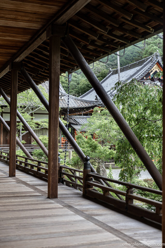 Wooden covered corridor at Bishamondo Temple framing garden and temple roofs in Kyoto
