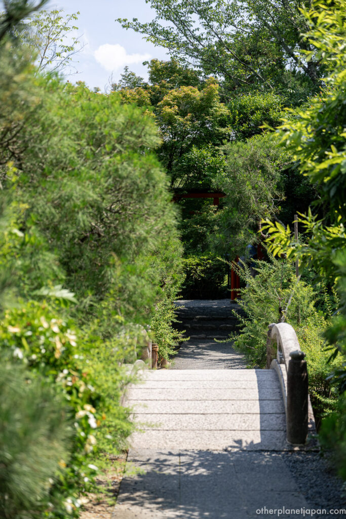 Stone bridge leading to a small shrine on an island in Kyoyochi Pond at Ryoanji
