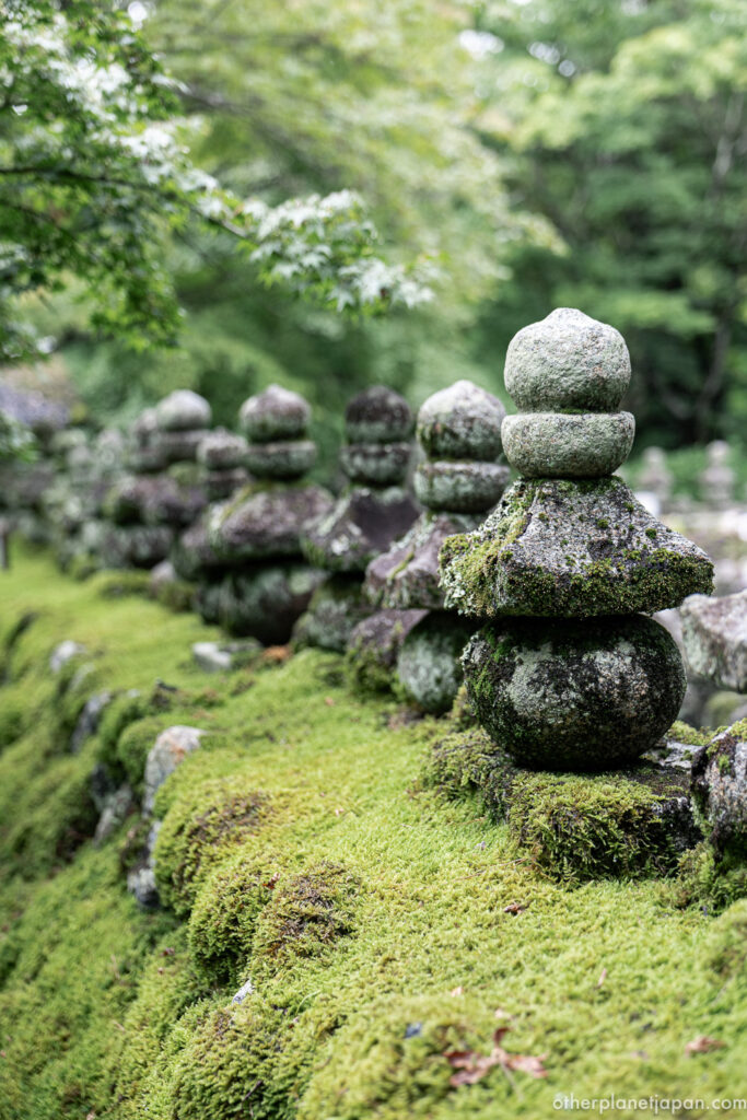 Row of moss-covered gorinto stone stupas at Adashino Nenbutsuji Temple