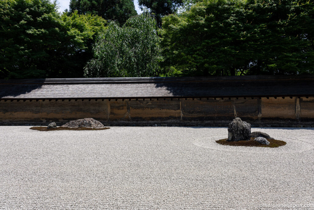 he famous Ryoanji Zen rock garden with fifteen stones on white gravel in Kyoto