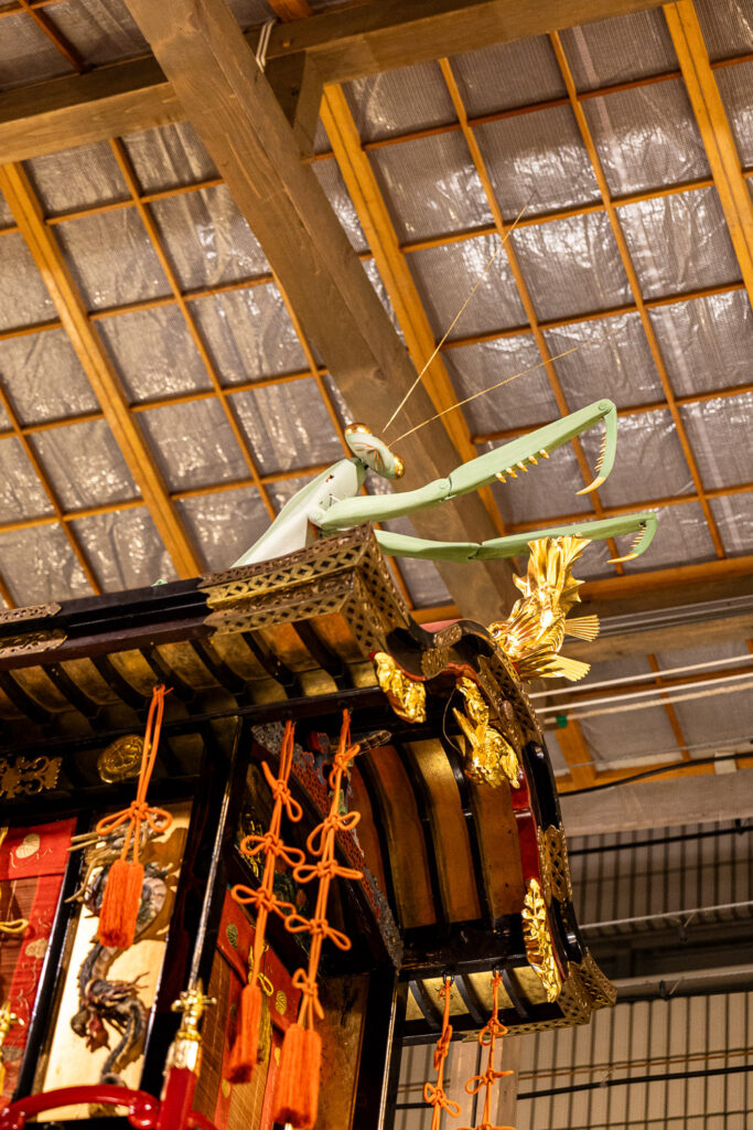 The green praying mantis figure with gold ornaments on the roof of the Toro Yama float at Gion Matsuri