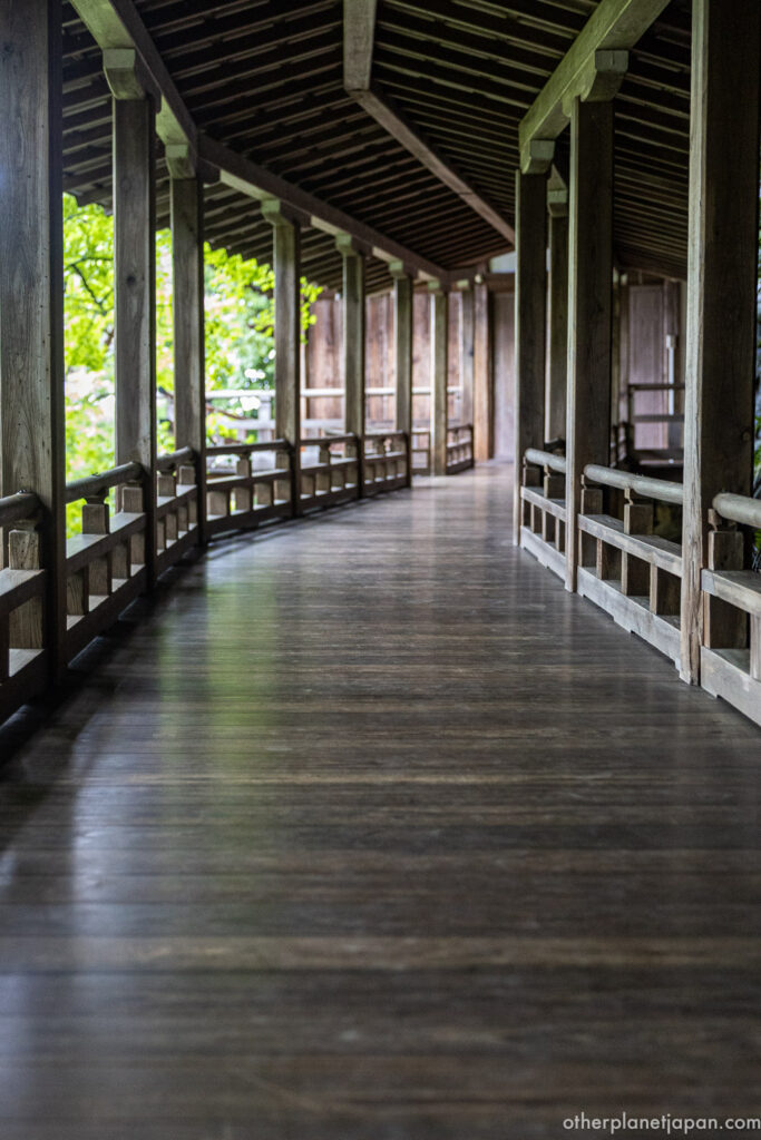 Curved wooden staircase of the Garyuro corridor descending through the trees at Eikando Temple, Kyoto