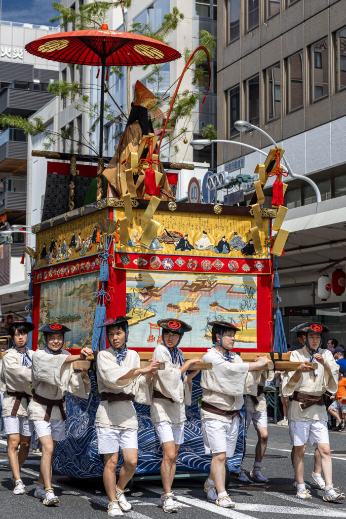 Bearers carrying a smaller yama float on shoulder poles through Kyoto