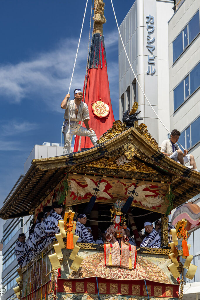 Roof riders and seated musicians on a Gion Matsuri float in Kyoto