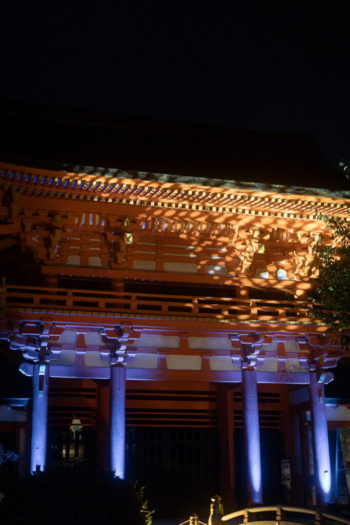 The vermilion romon gate of Kamigamo Shrine lit in orange and blue during the summer night illumination