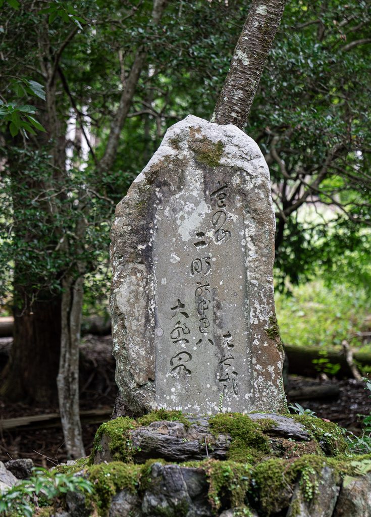 Moss-covered stone monument with carved haiku near Daihikaku Senkoji Temple in Arashiyama