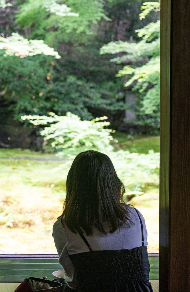 A visitor seated before the Ruri Garden at Rurikoin, where matcha is served