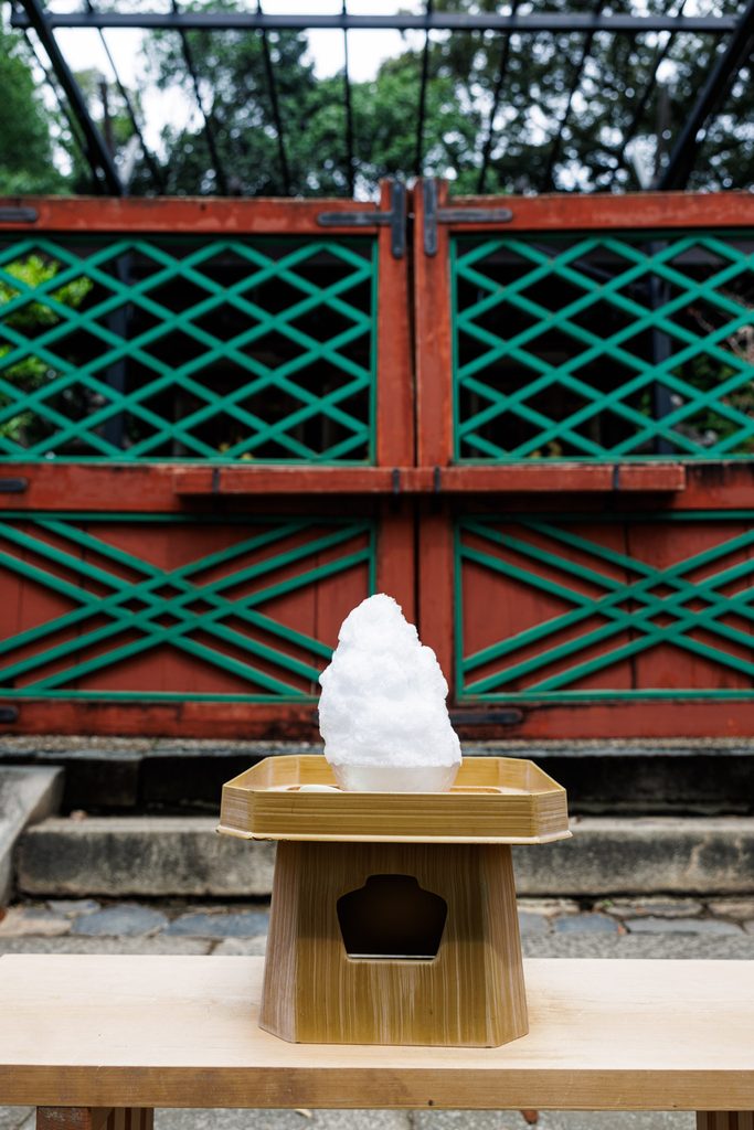 A bowl of shaved ice offered on a wooden stand before the sanctuary at Himuro Shrine