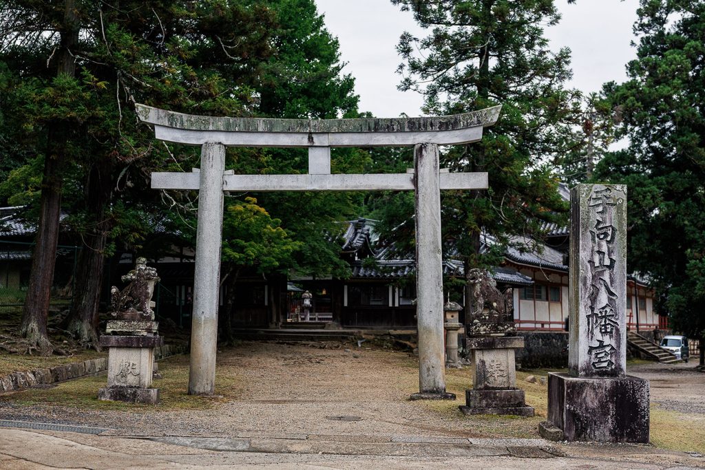 Stone torii gate and name pillar at the entrance of Tamukeyama Hachimangu Shrine in Nara Park