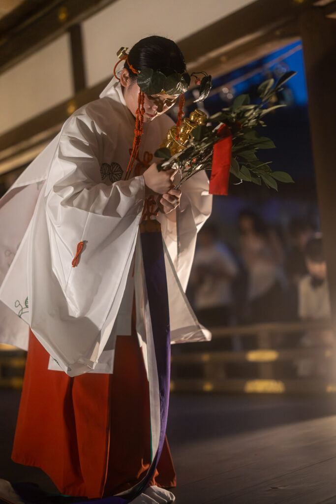A shrine maiden bowing at the end of the Kamo-no-Mai kagura dance at Kamigamo Shrine's summer illumination
