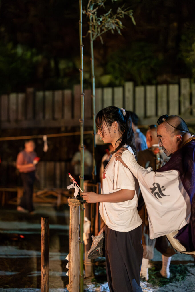 Participant receiving a blessing from a yamabushi monk before walking the fire bed at Tanukidani Fudoin