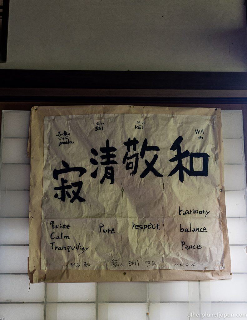 Hand-lettered calligraphy of wa kei sei jaku with English translations at Daihikaku Senkoji Temple