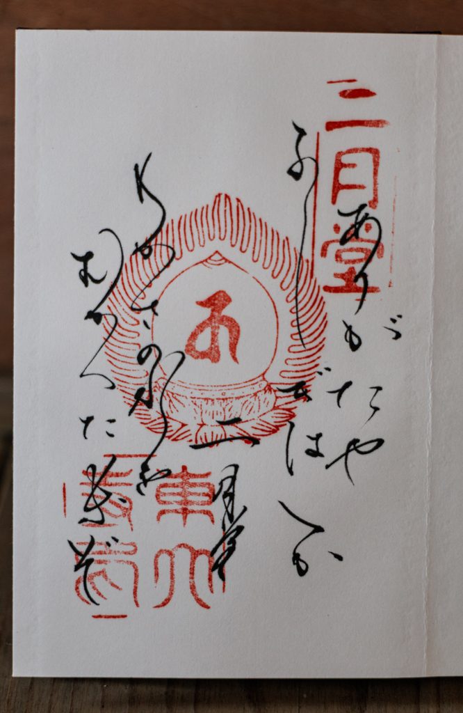 Nigatsudo goshuin with a waka poem about the Wakasa water written in cursive around a red seal