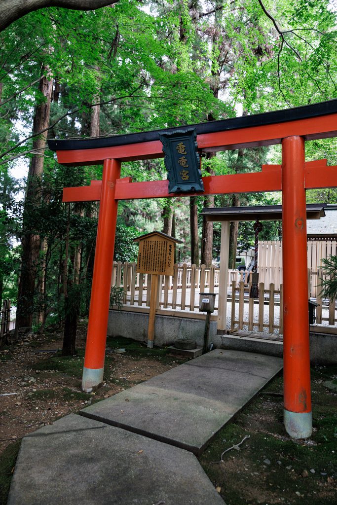 Vermilion torii gate of Denden-gu shrine at Horinji Temple, Arashiyama, with a black plaque