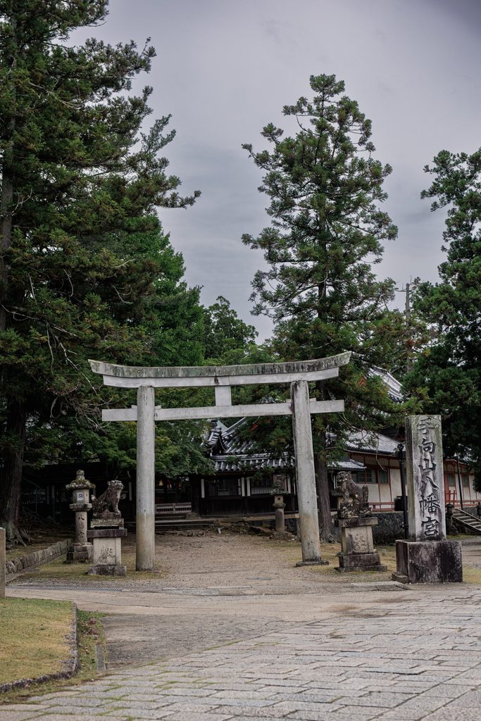 Stone torii gate of Tamukeyama Hachimangu shrine on the grounds of Todaiji, with a stone marker beside it