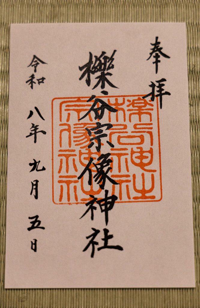 The goshuin of Ichitani-Munakata Shrine in Arashiyama, Kyoto, black calligraphy over a square vermilion seal