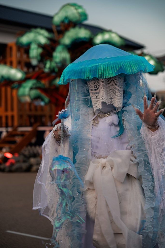 Performer in a translucent blue jellyfish yokai costume