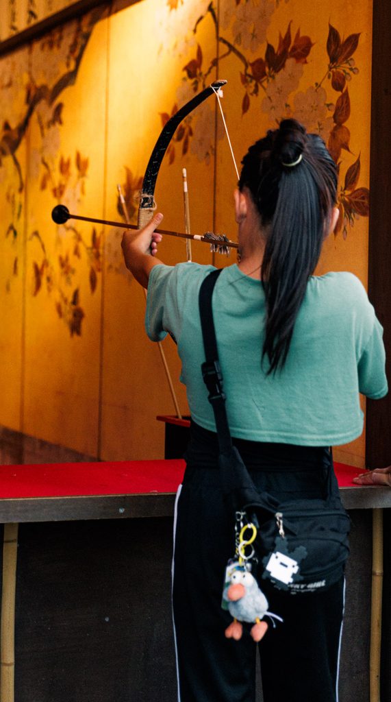 Visitor drawing a bow at the archery shooting gallery at Uzumasa Kyoto Village