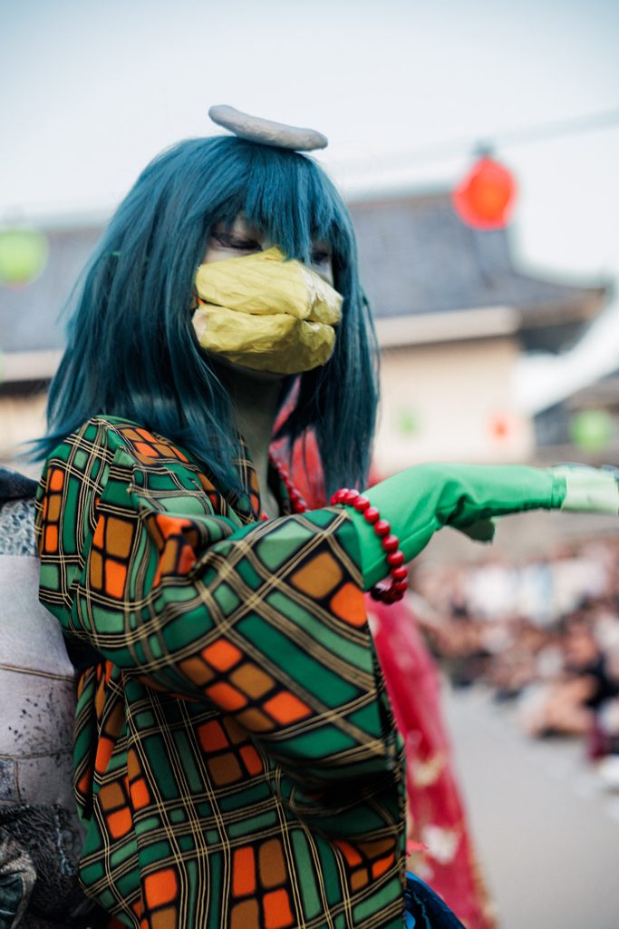 Kappa yokai performer with a yellow beak and green gloves in the parade