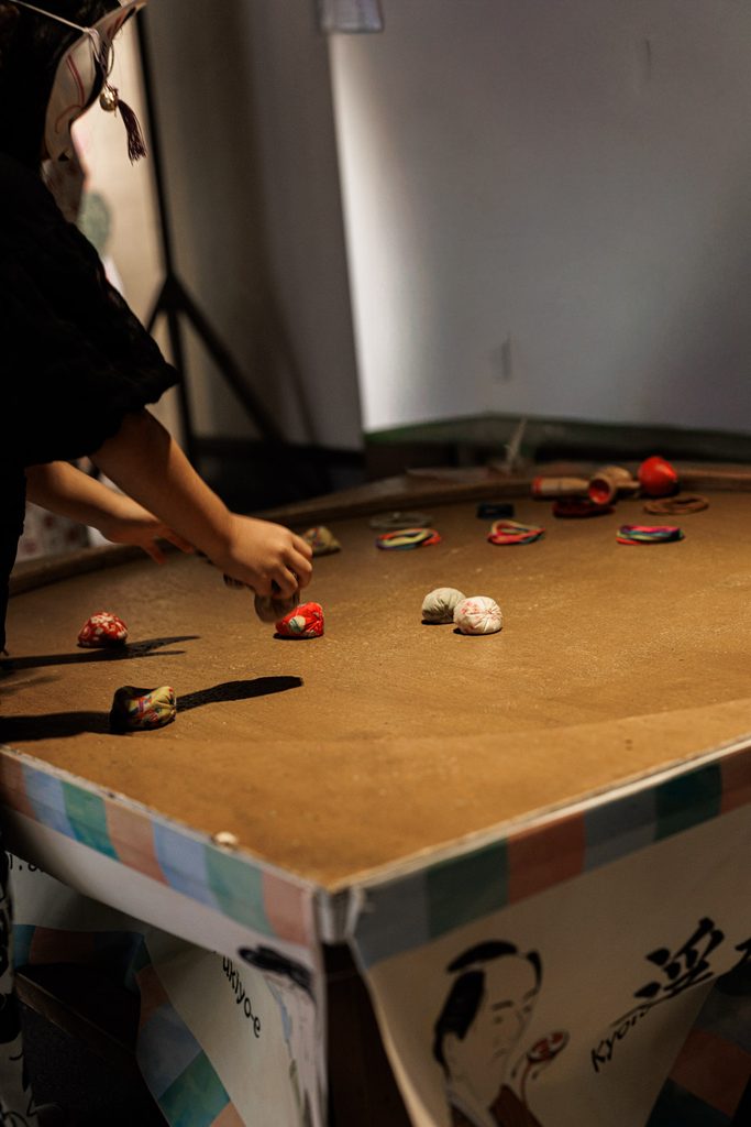 Visitor playing a traditional Japanese beanbag game at Uzuwaku Machiya