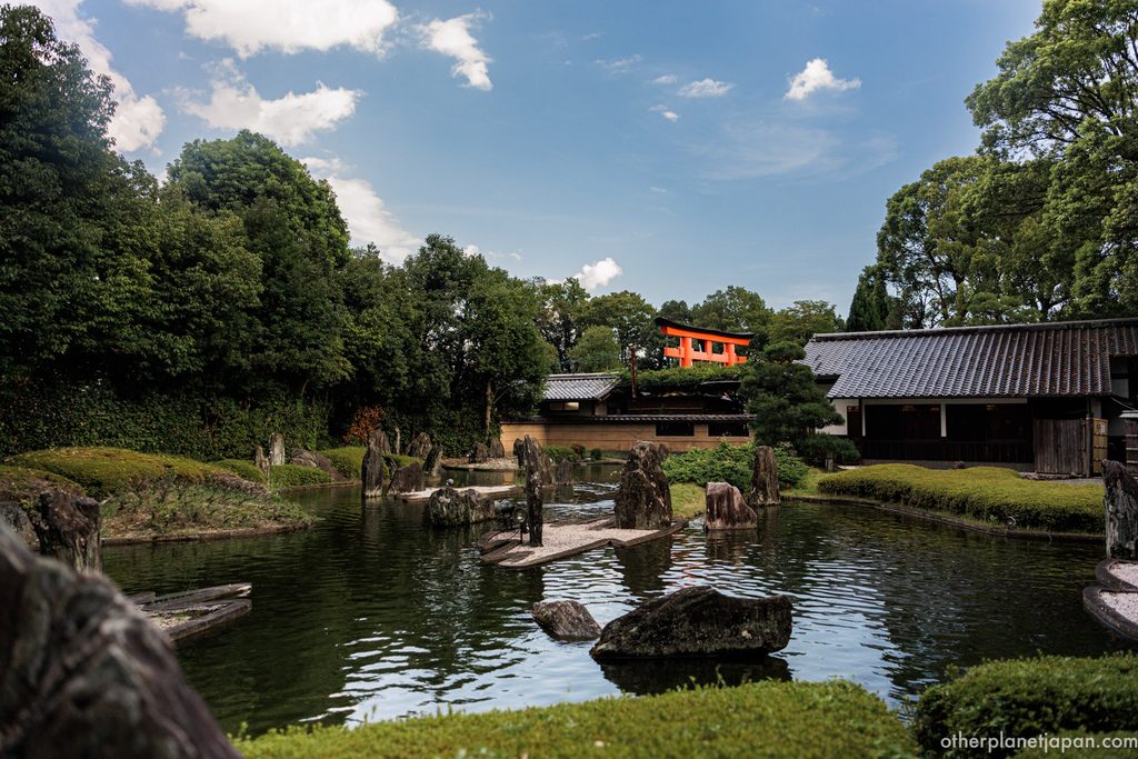 The pond of the Horai garden at Matsunoo Taisha with the great vermilion torii in the distance