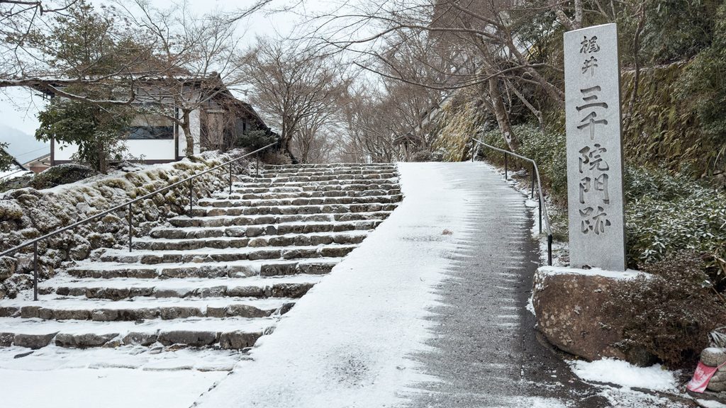 Snow-dusted stone steps and the Sanzenin Monzeki marker at the temple entrance in Ohara, Kyoto, in winter