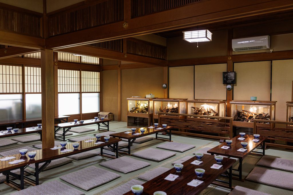 Tatami hall at Suzumushi-dera Temple set with low tables, cushions and cups of tea before a sermon session
